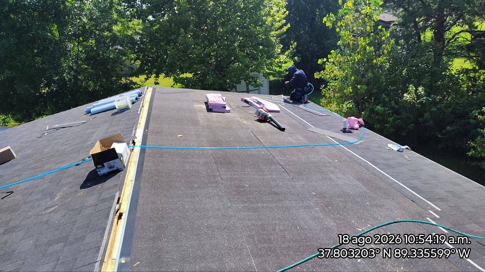 A JL Construction crew member installing roofing materials on a job site