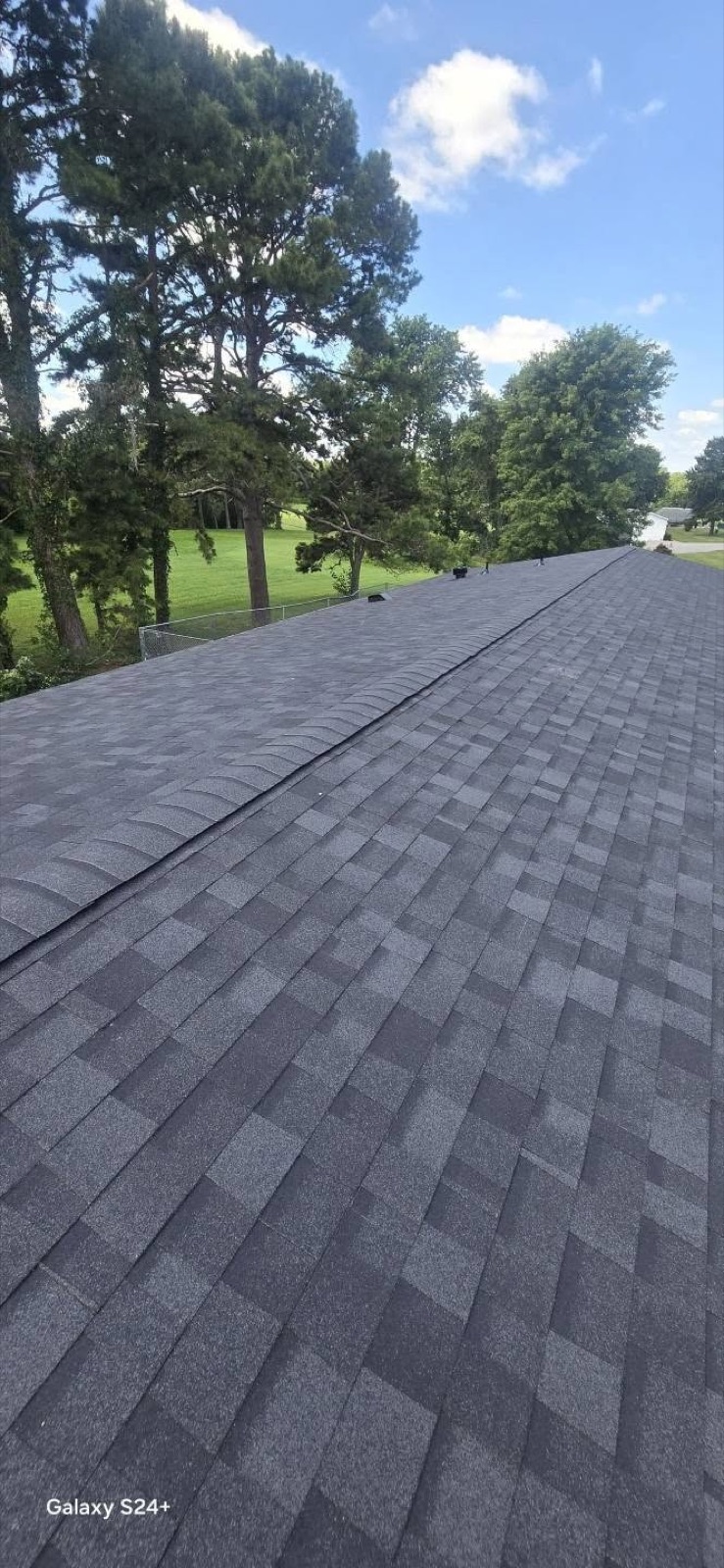 Freshly finished dark gray shingle roof, ridge line view