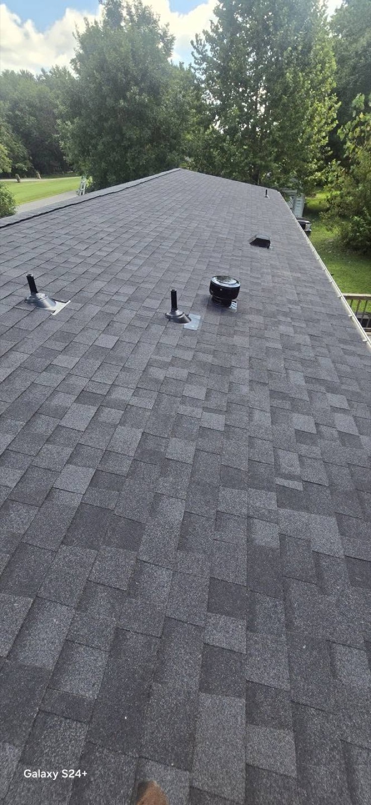 Completed shingle roof with vent pipes and boots installed cleanly